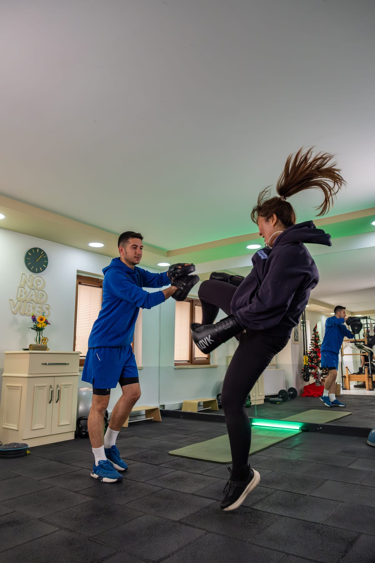 Kick-boks çalışması: eğitmen pedleri tutuyor, danışan diz atışı yapıyor