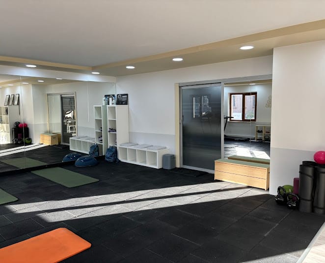 Poseidon Pilates stüdyosunun mat alanı: duvar boyu aynalar, matlar ve ekipman rafları